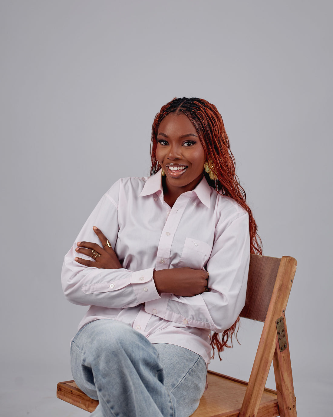 woman sitting on a chair with red box braids