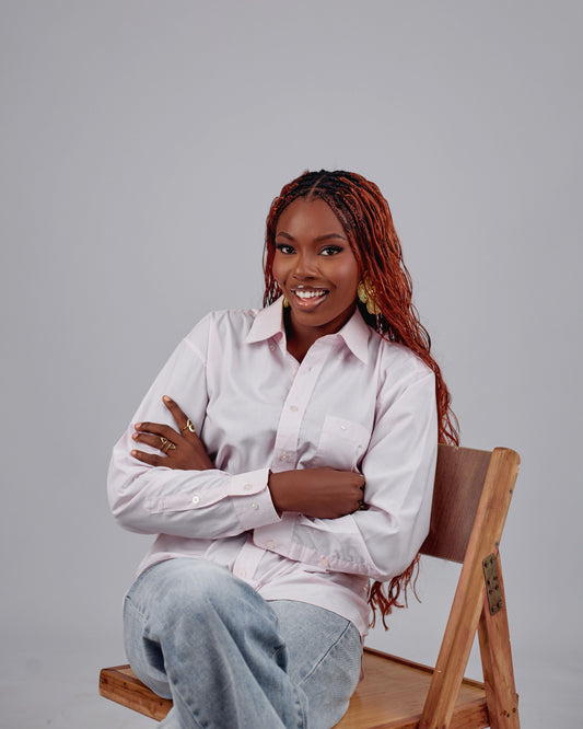 woman sitting on a chair with red box braids