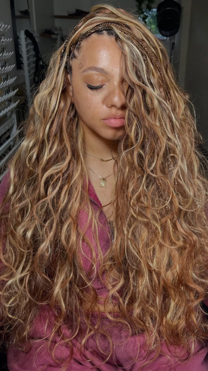 lady wearing long blonde human hair bundles in 24 inches from crown royale hair. she has the front of her hair in boho braids and is wearing the hybrid boho braids style. she sits on a chair with her eyes closed in red sports wear 
