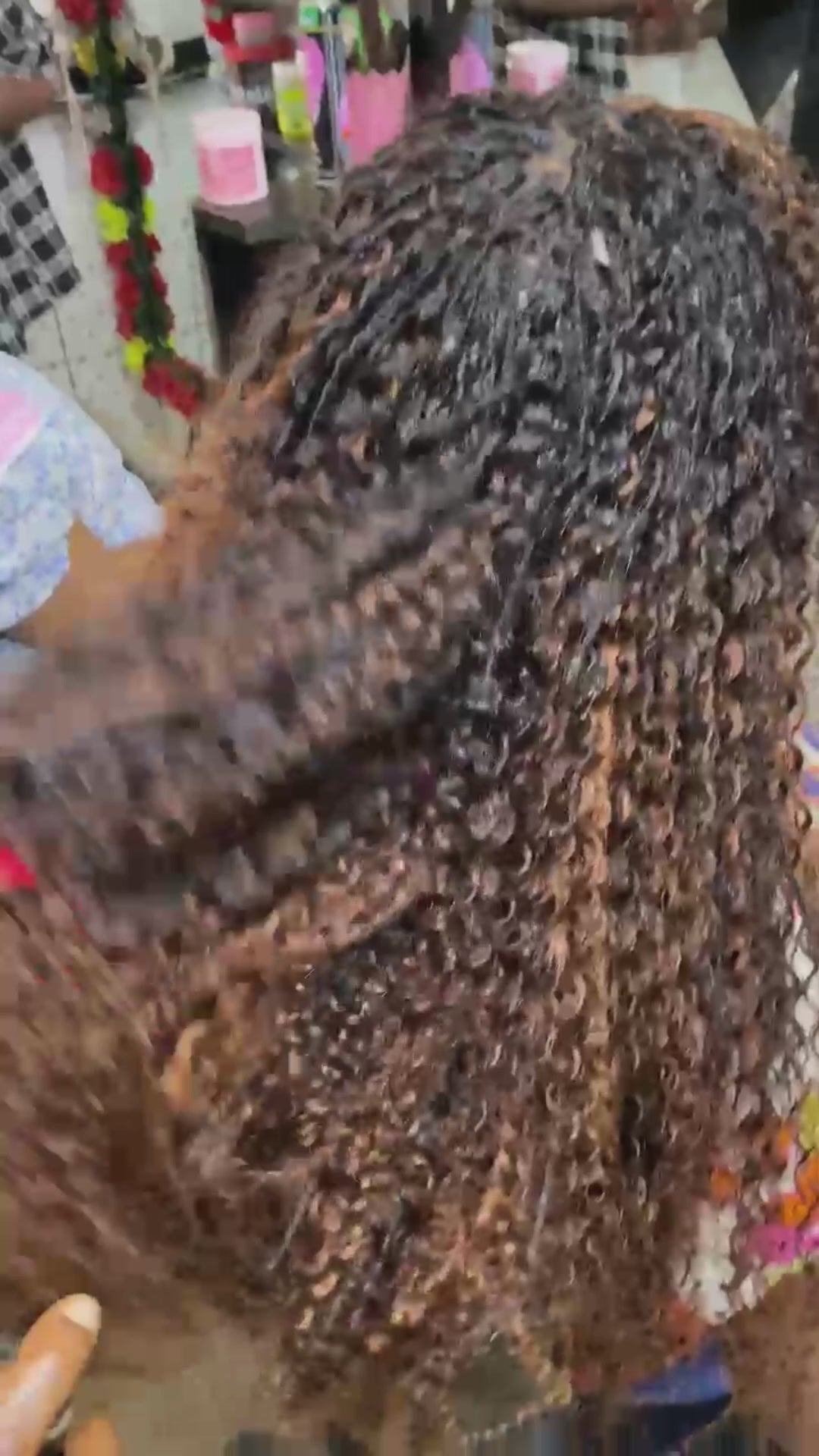 video showing sariette tichaa founder of crown royale hair getting her hair done in kinky curly mid back length boho braids dyed to an ombre caramel brown hair color using the crown royale hair human hair line