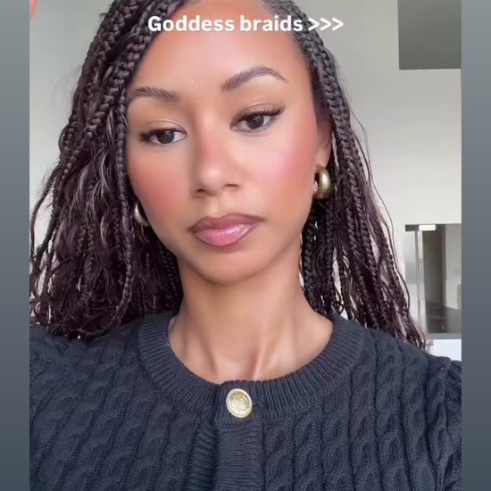 woman wearing waist length goddess braids in a brown colour showing off her new hairstyle