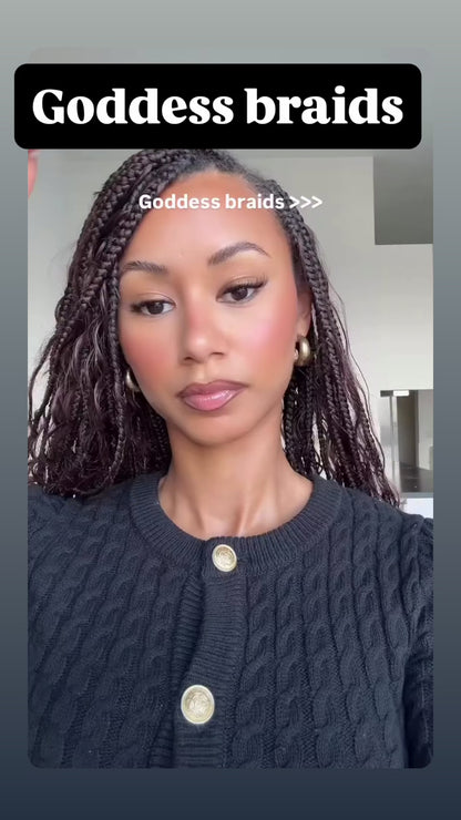 woman wearing waist length goddess braids in a brown colour showing off her new hairstyle