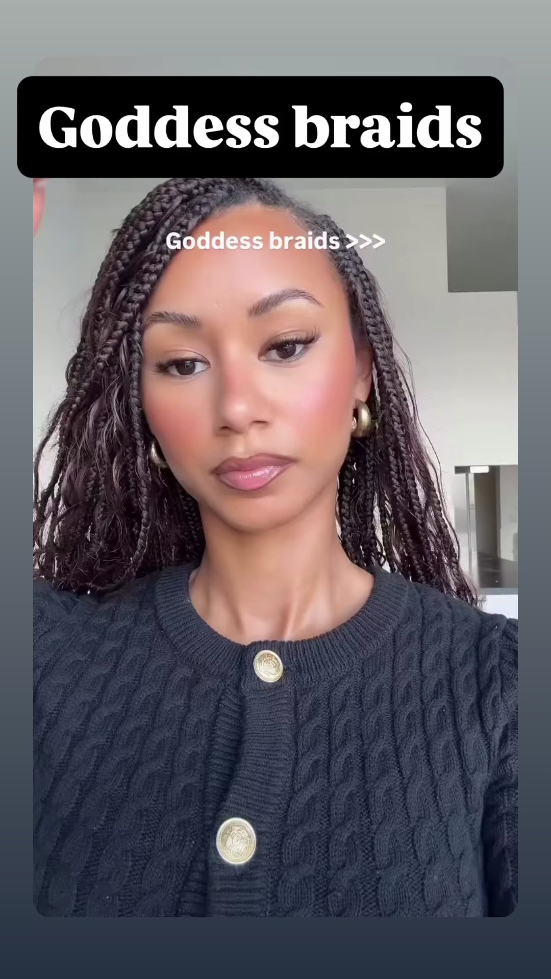 woman wearing waist length goddess braids in a brown colour showing off her new hairstyle