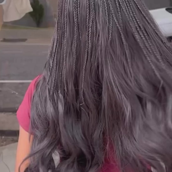 lady showing off her long wavy body wave human hair bundles from crown royale hair in 24 inches she has the top partof her braided in small braids