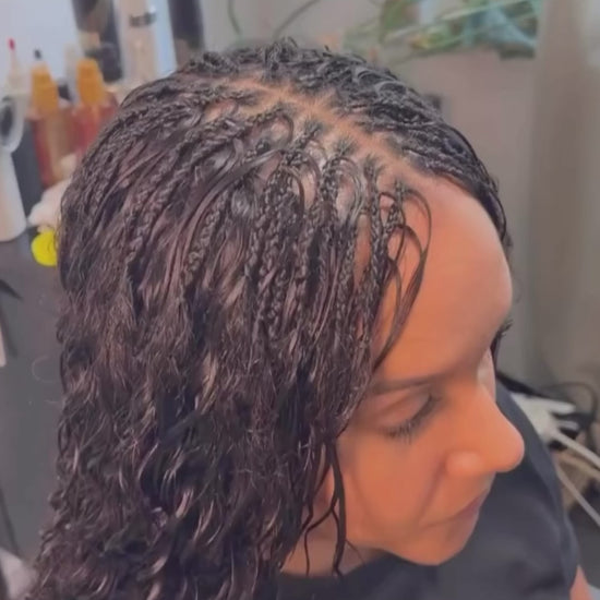 lady getting braided she is wearing a half weave and boho braids using wavy human hair from crown royale hair hair bundles 