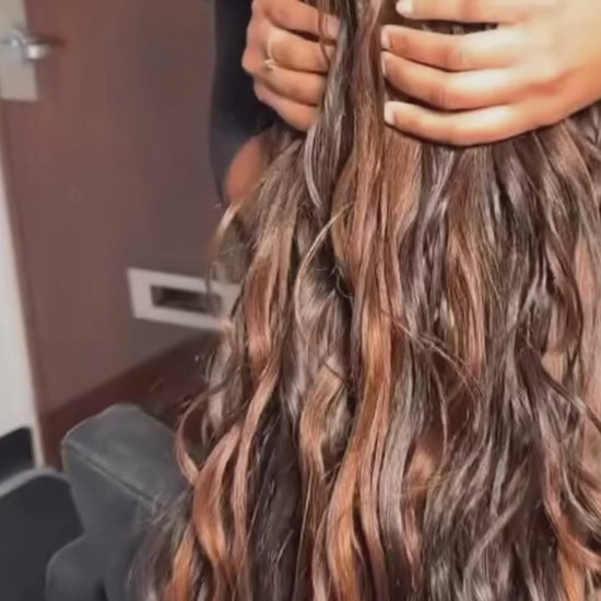 lady showing the back of her head she is wearing pick and drop boho braids and she has golden brown wavy long hair 