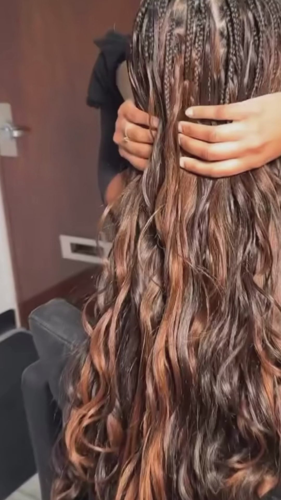 lady showing the back of her head she is wearing pick and drop boho braids and she has golden brown wavy long hair 